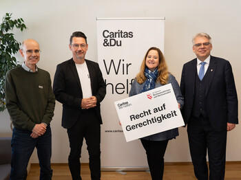 Besiegeln Partnerschaft: Rechtsanwaltskammerpräsident Bernhard Fink (re), Kammeramtsdirektorin Susanne Laggner-Primosch, Caritasdirektor Ernst Sandriesser und Caritas-Jurist Peter Leitner (li) Caritas-Jurist Peter Leitner, Caritasdirektor Ernst Sandriesser, Kammeramtsdirektorin Susanne Laggner-Primosch und Rechtsanwaltskammerpräsident Bernhard Fink stehen vor einem Caritas-Rollup und halten ein Schild Recht auf Gerechtigkeit in der Hand.