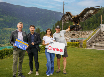 Spektakuläre Begegnung mit einem Greifvogel: Ernst Sandriesser und Roberta Striedinger von der Caritas danken Anton Fasching (li) beim Besuch in der Adlerarena Burg Landskron für die 250 Kärnten Card-Saisonpakete