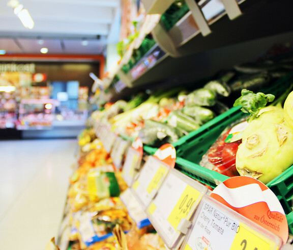 Ein Gemüseregal im SPAR Supermarkt Perspektive Handel in Villach, im Hintergrund sieht man die Frischfleisch-Theke.