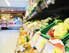 Ein Gemüseregal im SPAR Supermarkt Perspektive Handel in Villach, im Hintergrund sieht man die Frischfleisch-Theke.