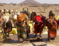 Afrikaner*innen holen gemeinschaftlich Wasser aus den Tiefen Brunnen, während im Land eine Dürre herrscht.