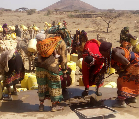 Afrikaner*innen holen gemeinschaftlich Wasser aus den Tiefen Brunnen, während im Land eine Dürre herrscht.