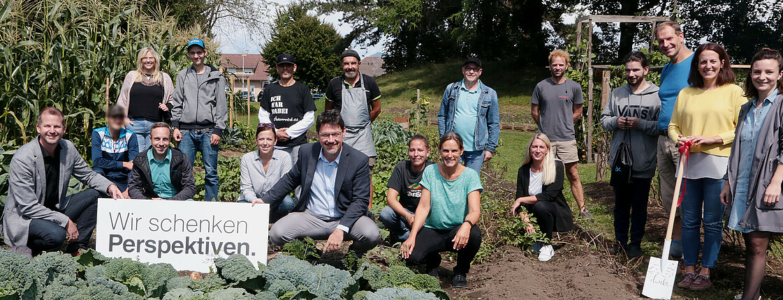 Die Flex Foundation mit den Projektverantwortlichen sowie Menschen, die im Beschäftigungsprojekt Arbeit gefunden haben, vor den Beeten unseres grown.care-Gartens. Unser Beschäftigungsprojekt grown.care ein Garten indem allerlei Gemüse angebaut wird, wird von Unternehmen finanziert.